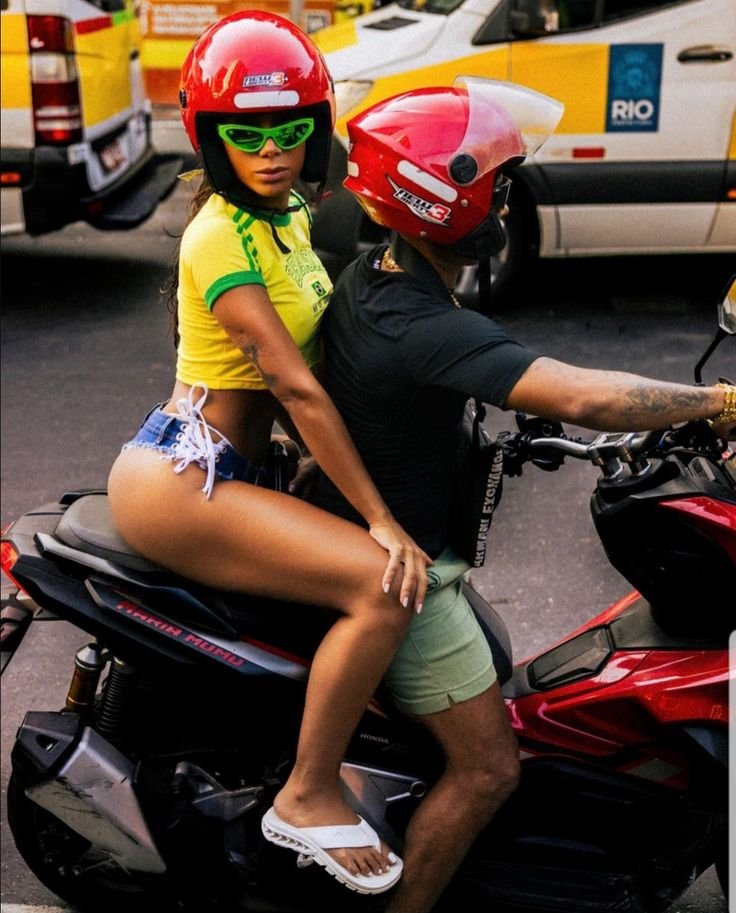 Anitta anda de moto em comunidade no Rio, com blusa do Blusa retrô do Brasil, para gravar clipe