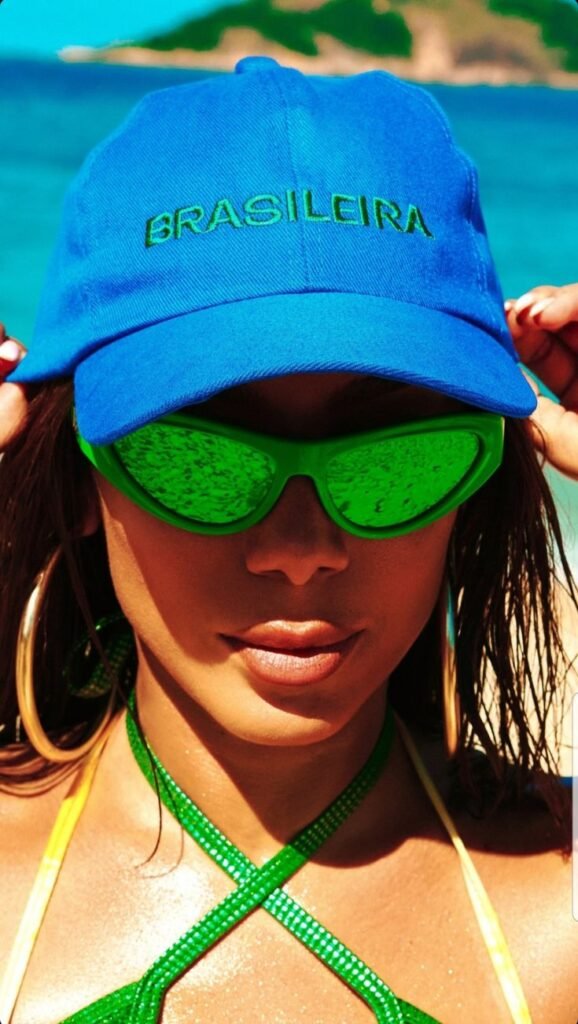 cantora anita na praia usando Boné Azul "Brasileira" + Óculos Verde Neon